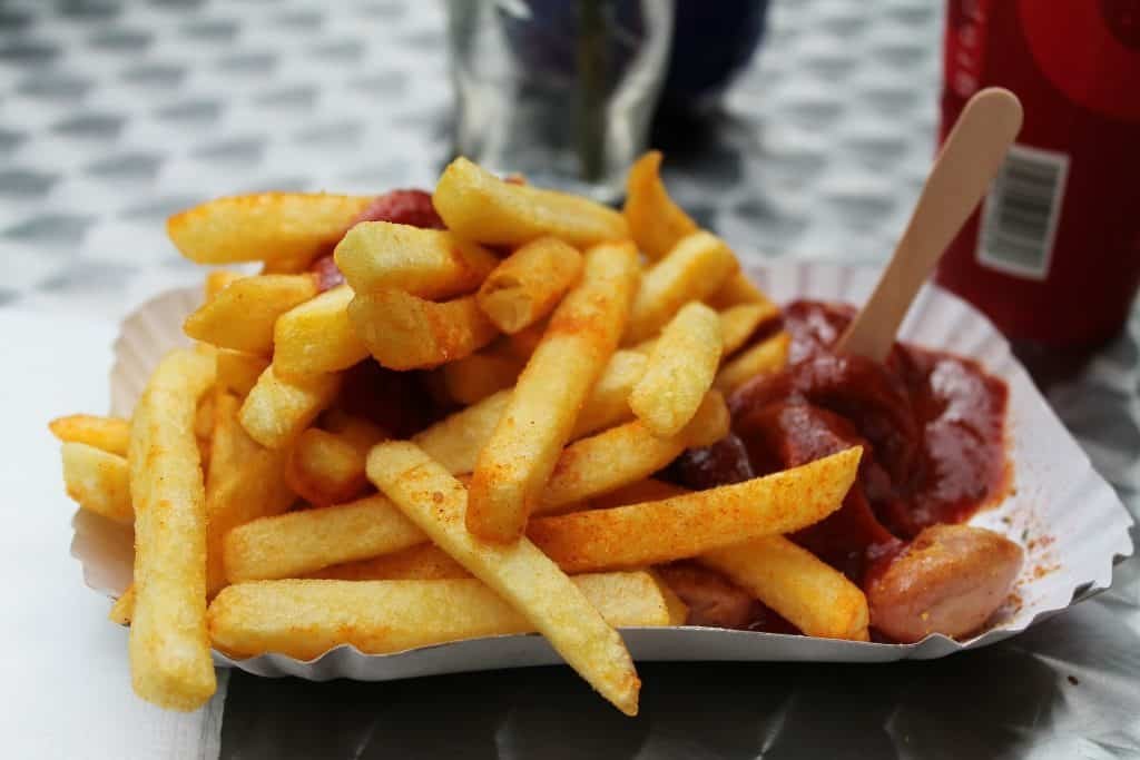 We love Currywurst! But do you know who invented it, what it is exactly and why this curried sausage became such a popular street snack?