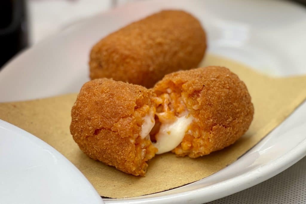 Deep fried croquettes of tomato risotto stuffed with a gooey melted mozzarella heart? Try our recipe for rice balls, or classic Roman suppli in rosso!